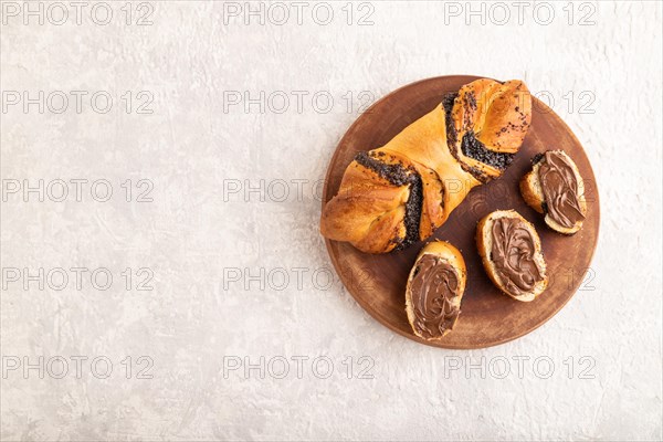 Homemade sweet bun with chocolate cream on a gray concrete background. top view, flat lay, copy space