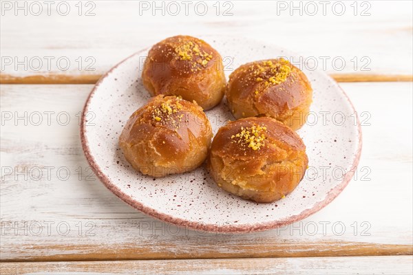 Homemade traditional turkish dessert sekerpare with almonds and honey on white wooden background. side view, close up