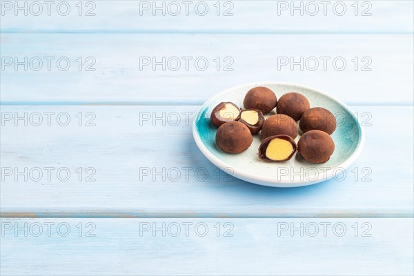 Japanese rice sweet buns chocolate mochi filled with cream on blue wooden background. side view, copy space