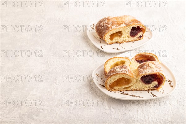 Homemade sweet bun with apricot jam on gray concrete background. side view, copy space