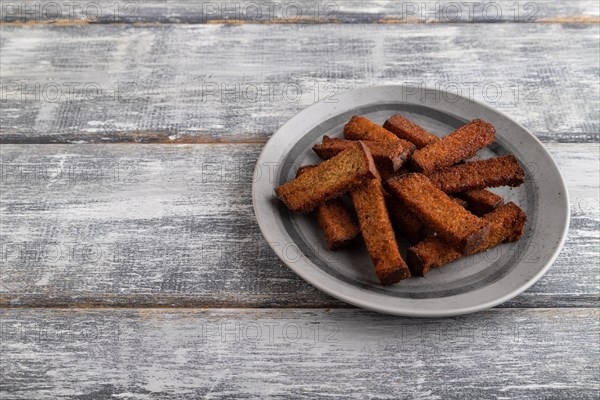 Toast on a gray plate on a gray wooden background. Side view, close up, copy space