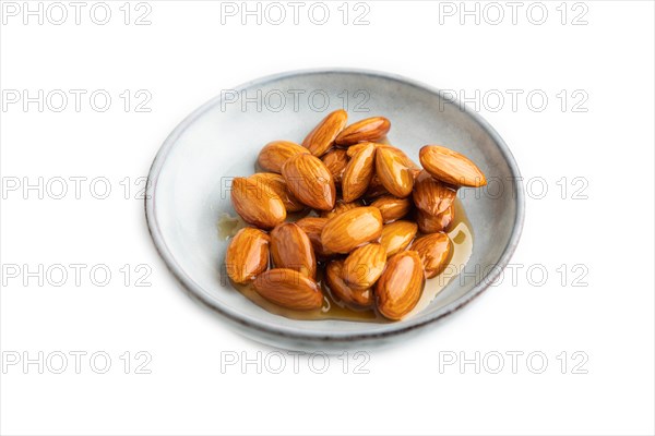 Almonds with honey isolated on white background. side view, close up