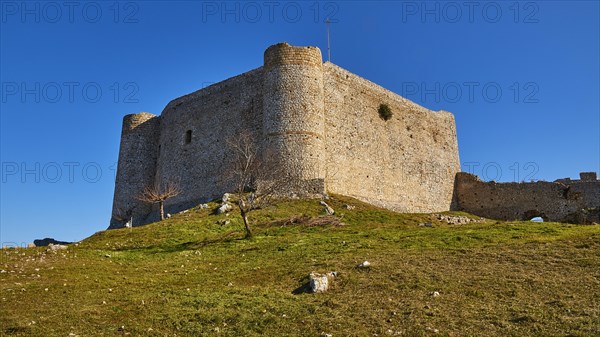 Ancient stone castle on a hill with green grass and clear blue sky, Chlemoutsi, High Medieval Crusader Castle, Kyllini Peninsula, Peloponnese, Greece, Europe