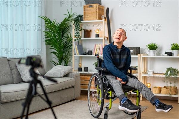 Disabled man recording a video tutorial at home using a digital camera and tripod