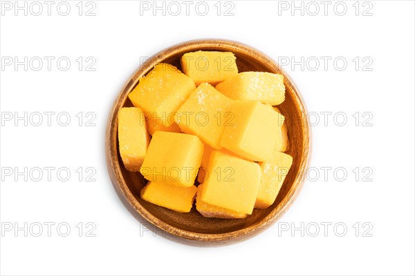 Dried and candied mango cubes in wooden bowls isolated on white background. Top view, flat lay, close up, vegan, vegetarian food concept