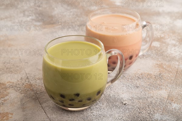 Bubble tea with pistachio and caramel in glass on brown concrete background. Healthy drink concept. Side view, close up