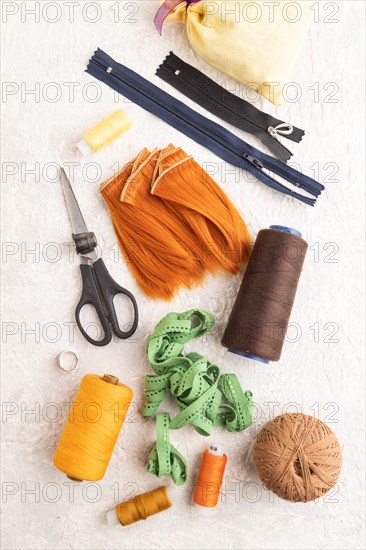 Sewing accessories: scissors, thread, thimbles, braid on gray concrete background. Top view, flat lay, close up