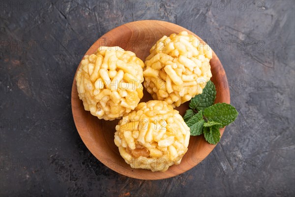 Traditional Tatar candy chak-chak made of dough and honey in wooden plate on a black concrete background. top view, flat lay, close up