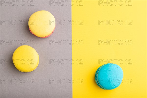 Yellow and blue macaroons on trendy gray and yellow background. top view, copy space, flat lay, close up, still life. Minimalism, morning, contrast concept