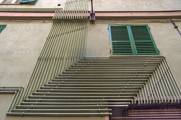 Water pipes on an exterior wall of a residential building in the historic centre, Genoa, Italy, Europe