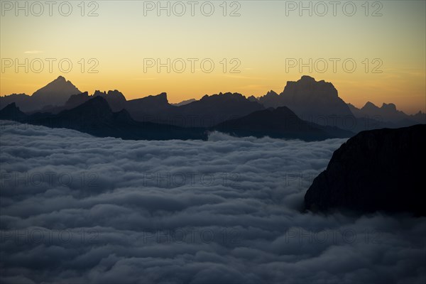 Sunrise over a sea of fog with the peaks of the Sella massif in the background, Corvara, Dolomites, Italy, Europe