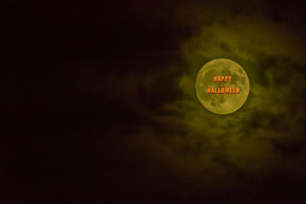Happy Halloween in orange and red letters across face of full moon surrounded by clouds in South Korea
