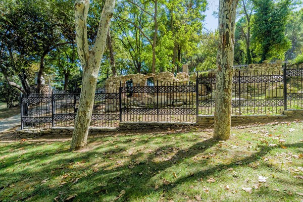 Ruins of ancient roman era behind black iron fence in public park in Istanbul, Tuerkiye