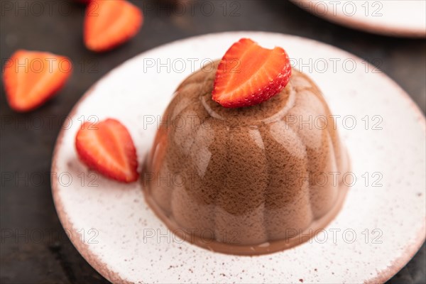 Chocolate jelly with strawberry on black concrete background. side view, close up, selective focus