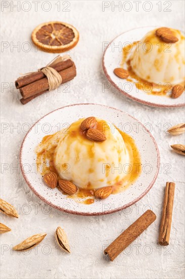 White milk jelly with caramel sauce on gray concrete background. side view, close up