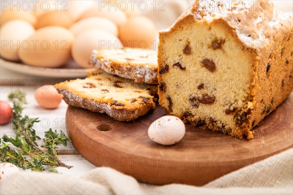 Homemade easter pie with raisins and eggs on plate on a white wooden background and linen textile. side view, close up, selective focus