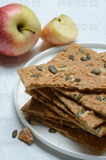 Crispbread with seeds on a plate and apple