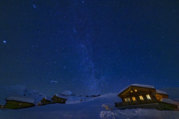 Mountain huts at night under a clear starry sky with illuminated windows in winter, Belalp, Naters, Brig, Canton Valais, Switzerland, Europe