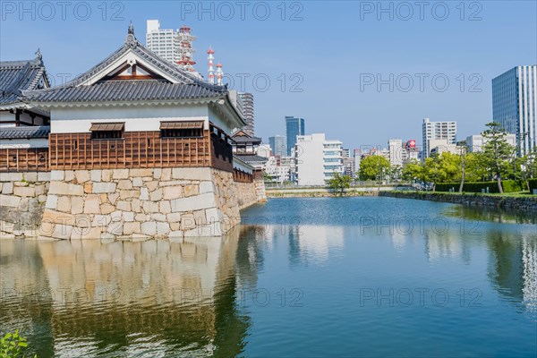 Ancient Hiroshima palace and mote with city buildings in background in Hiroshima, Japan, Asia