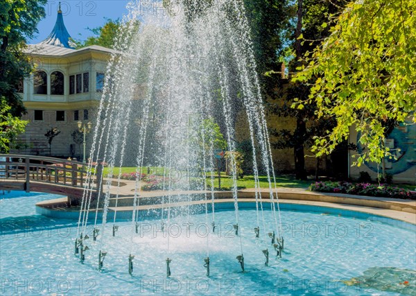 Water fountain in shallow pool in public park on sunny afternoon in Istanbul, Tuerkiye