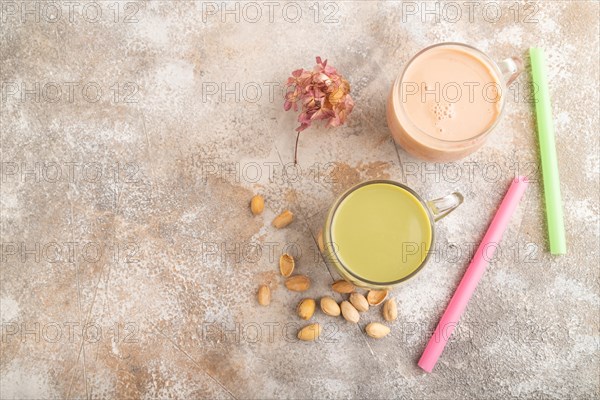 Bubble tea with pistachio and caramel in glass on brown concrete background. Healthy drink concept. Top view, flat lay, copy space