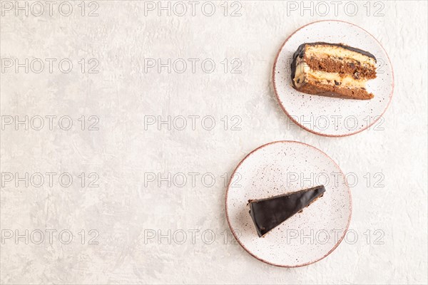 Chocolate biscuit cake with caramel cream and walnuts, on gray concrete background. top view, flat lay, copy space