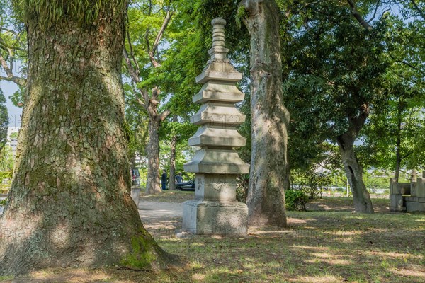 Stone carved pagoda in shady area of Peace Memorial Park in Hiroshima, Japan, Asia