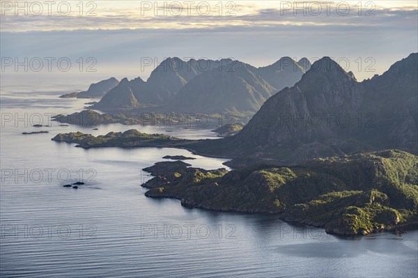 View of the coast in Ulvagsundet fjord and mountains in the evening light, Hurtigruten cruise ship in the fjord, view from the summit of Dronningsvarden or Stortinden, Vesteralen, Norway, Europe