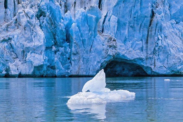 Ice floe floating in the sea at a glacier with a cave in the arctic, Svalbard