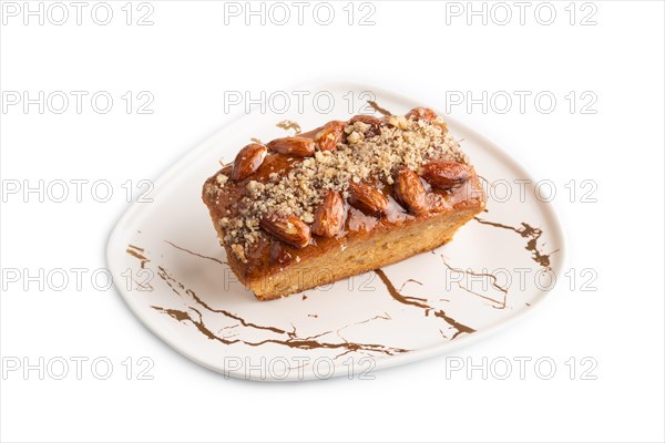 Caramel and almond cake isolated on white background. side view, close up