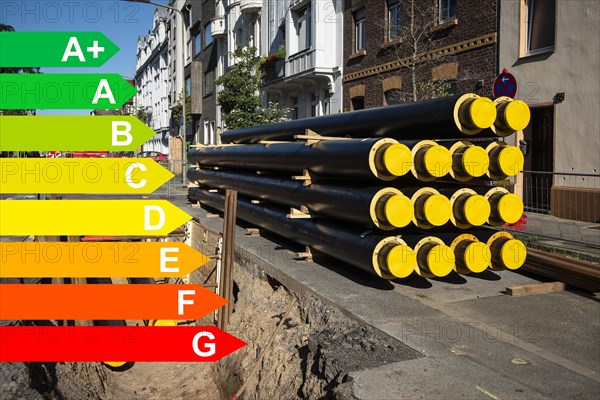 A stack of new pipes for district heating at a construction site, graphic with energy efficiency classes for buildings according to the GEG, Duesseldorf, Germany, energy efficiency, Europe