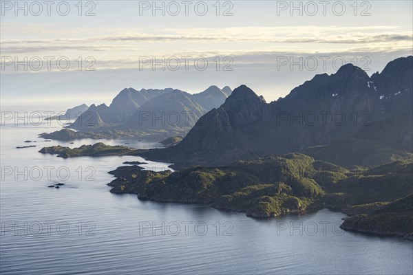 View of the coast in Ulvagsundet fjord and mountains in the evening light, Hurtigruten cruise ship in the fjord, view from the summit of Dronningsvarden or Stortinden, Vesteralen, Norway, Europe