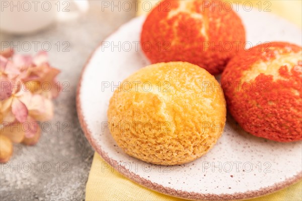 Traditional french custard dessert shu cake and cup of green tea on brown concrete background and yellow linen textile. side view, selective focus. Breakfast, morning, concept