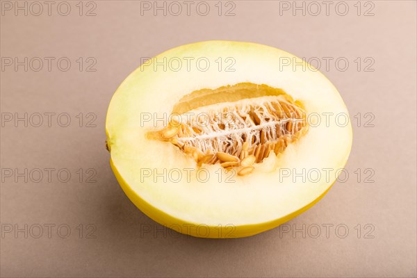 Sliced ripe yellow melon on brown pastel background. Side view, close up. harvest, women health, vegan food, concept, minimalism