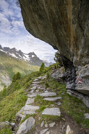 Hiking trail under a rocky outcrop in a picturesque mountain landscape, Berliner Hoehenweg, Zillertal Alps, Tyrol, Austria, Europe