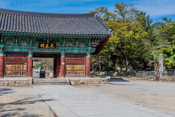 Building with ceramic tiled roof at entrance to Geumsansa temple under blue sky in Gimje-si, South Korea, Asia