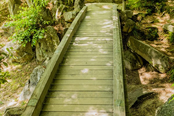 Shaded wooden footbridge in Japanese Shukkeien Gardens in Hiroshima, Japan, Asia