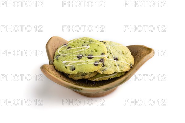 Green cookies with chocolate and mint on leaflike ceramic plate isolated on white background. side view, close up