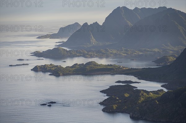 View of the coast in Ulvagsundet fjord and mountains in the evening light, Hurtigruten cruise ship in the fjord, view from the summit of Dronningsvarden or Stortinden, Vesteralen, Norway, Europe