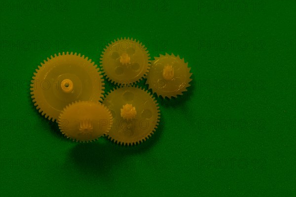 Yellow hard plastic cog sprocket wheels on green background