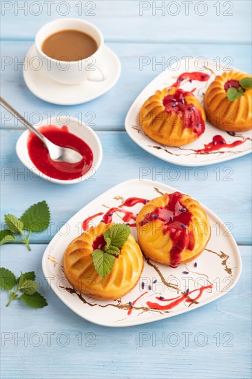 Semolina cheesecake with strawberry jam, lavender, cup of coffee on blue wooden background. side view, close up