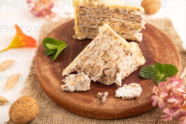 Walnut and almond cake on white wooden background and linen textile. side view, close up, selective focus