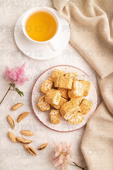Traditional turkish delight (rahat lokum) with cup of green tea on a gray concrete background and linen textile. top view, flat lay, close up