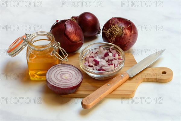 Honey in a jar and chopped onion as ingredients for cough syrup