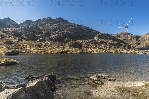 Wind turbine on a mountain lake on the Gotthard Pass, Canton Ticino, Switzerland, Europe