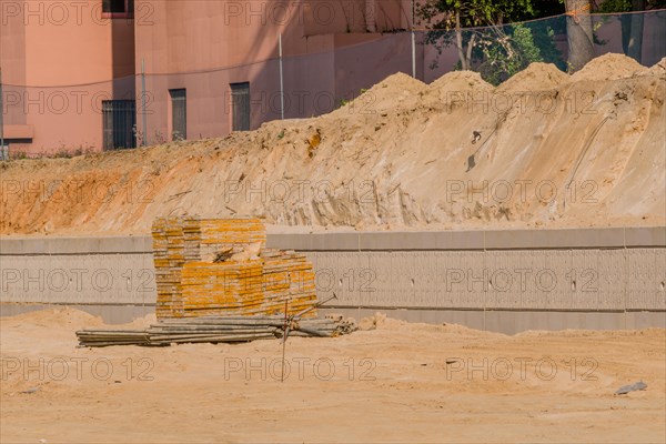 Concrete forms and iron scaffold pipes stacked neatly in front of concrete wall at construction site in South Korea