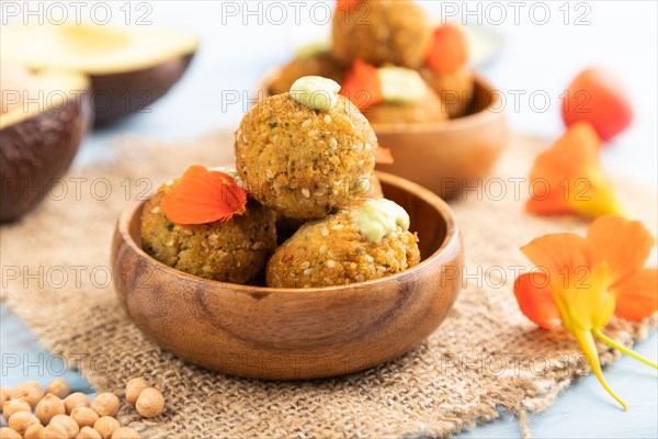 Falafel with guacamole on blue wooden background and linen textile. Side view, close up, selective focus