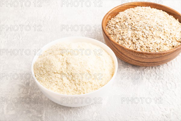 Powdered milk and oatmeal, baby food mix, infant formula on gray concrete background. Side view, artificial feeding concept