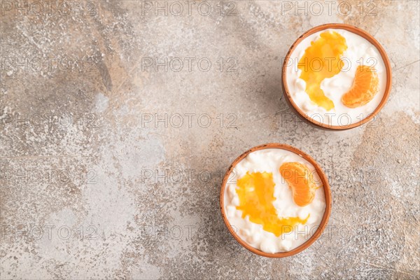 Grained cottage cheese with tangerine jam on brown concrete background. top view, flat lay, copy space