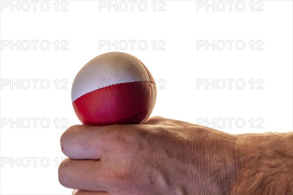 Hand with a juggling ball in front of a white background, studio shot, Germany, Europe